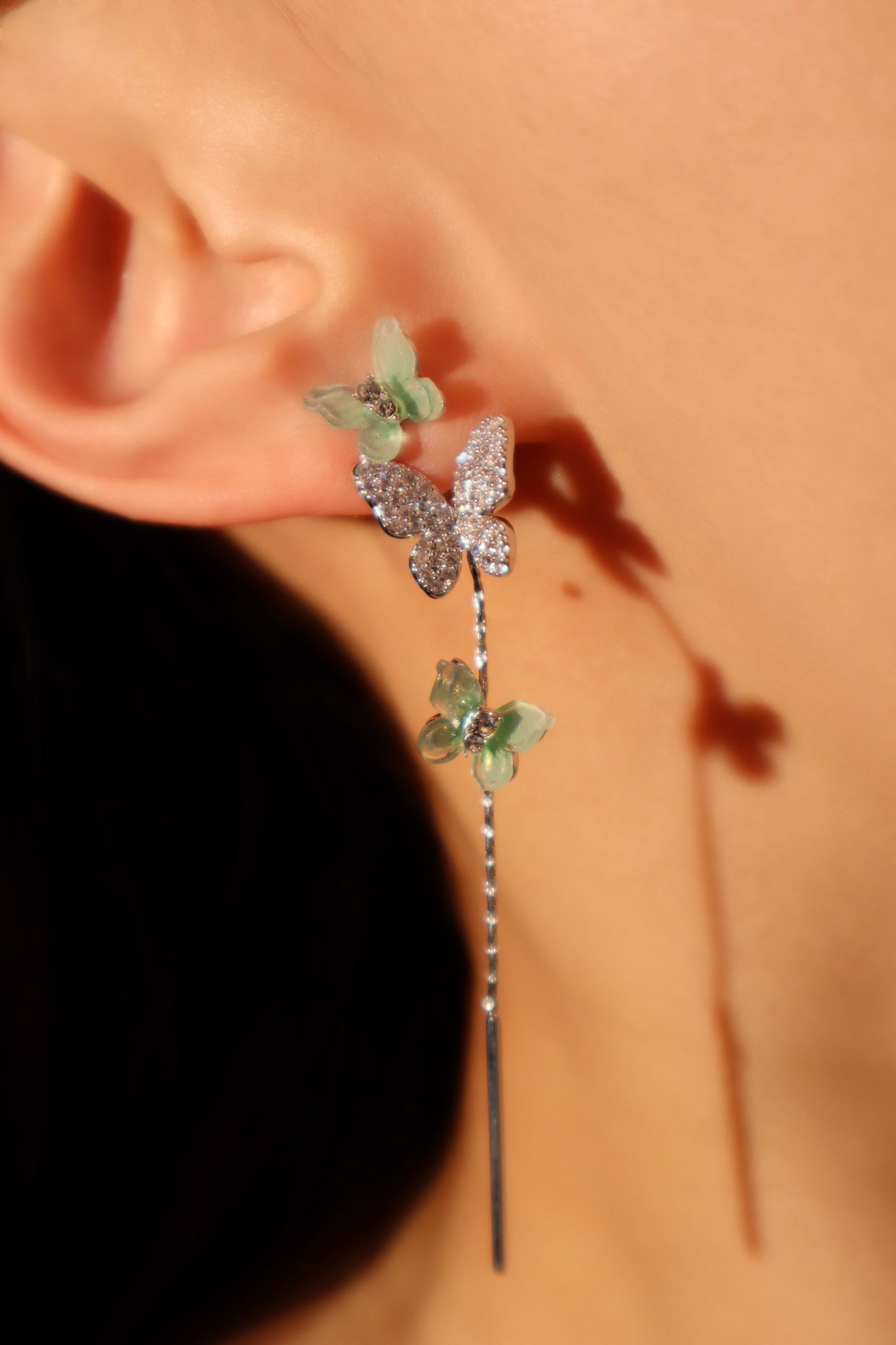 Aretes de mariposa verdes con diamantes