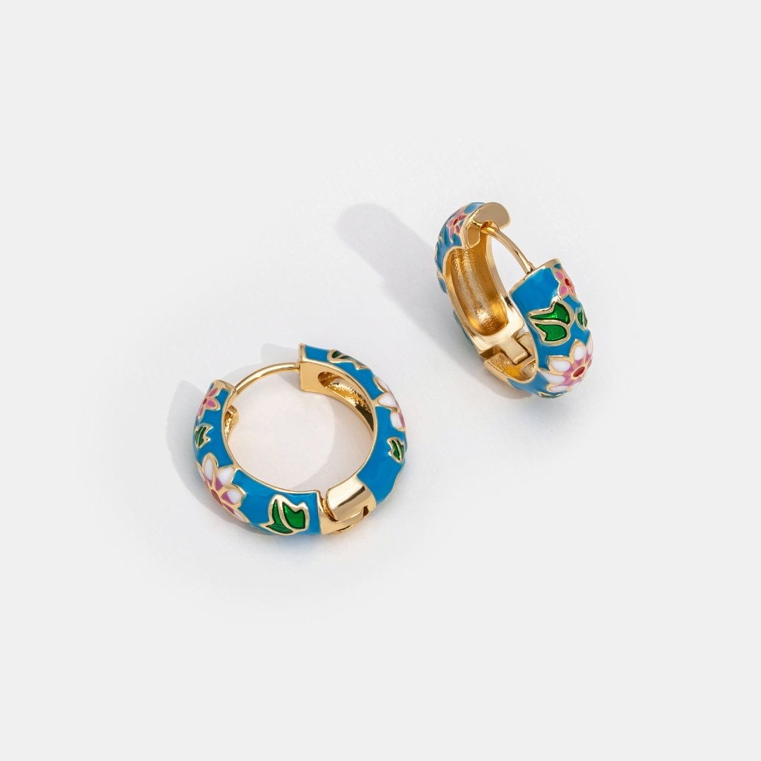 Aretes de círculo dorados con flor