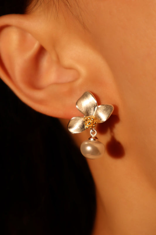 Pendientes de metal mezclado con orquídea blanca