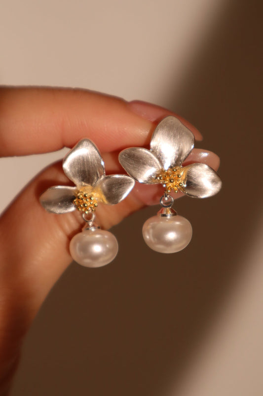 Pendientes de metal mezclado con orquídea blanca